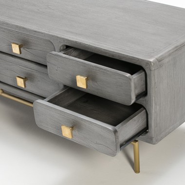 Mueble de televisión de madera gris con patas y tiradores en metal dorado.