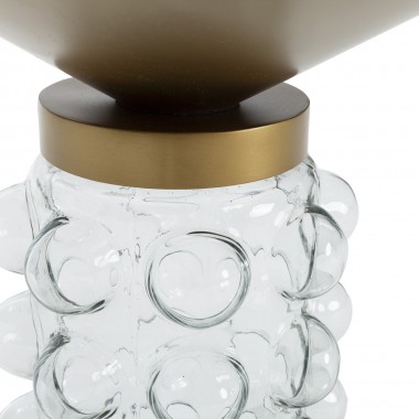Mesa auxiliar con base de vidrio y sobre redondo de metal en dorado.