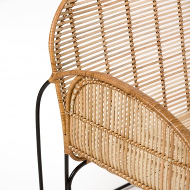 Sillón de mimbre con patas metálicas ligeras lacadas en negro.