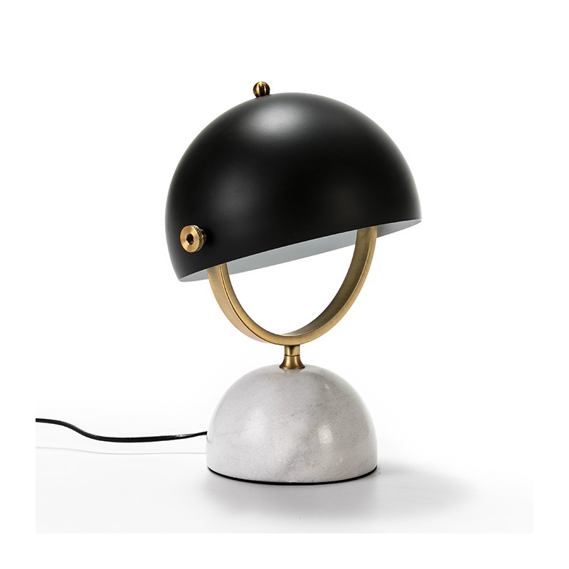 Lámpara de mesa con base de mármol blanco y pantalla semicircular metálica en negro y dorado.