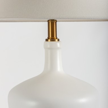 Lámpara de mesa con base cerámica blanca y detalles en dorado.