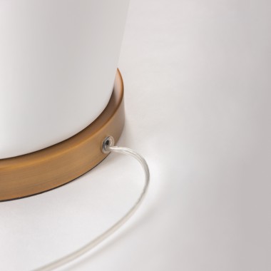 Lámpara de mesa con base cerámica blanca y detalles en dorado.
